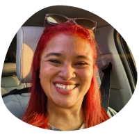 Mobile Groomber Monica in Chicagoland A picture of Monica who is sitting in a car, with red hair and smiling.